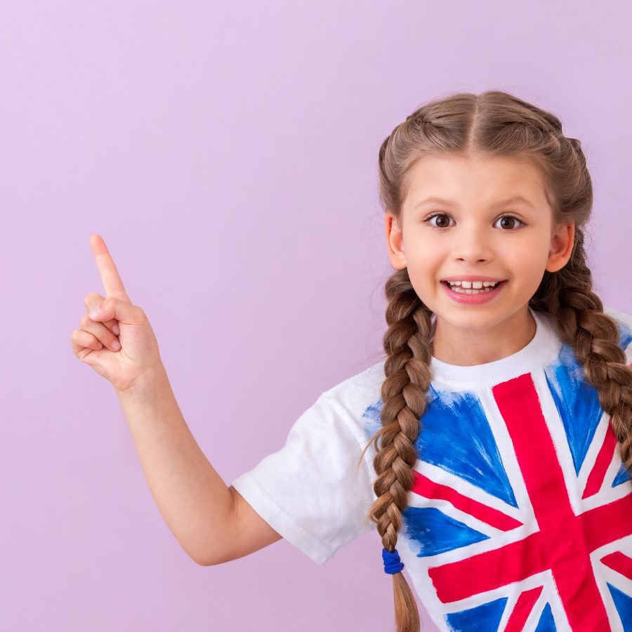 nino-camiseta-bandera-britanica-senala-su-anuncio-sobre-fondo-rosa-aislado